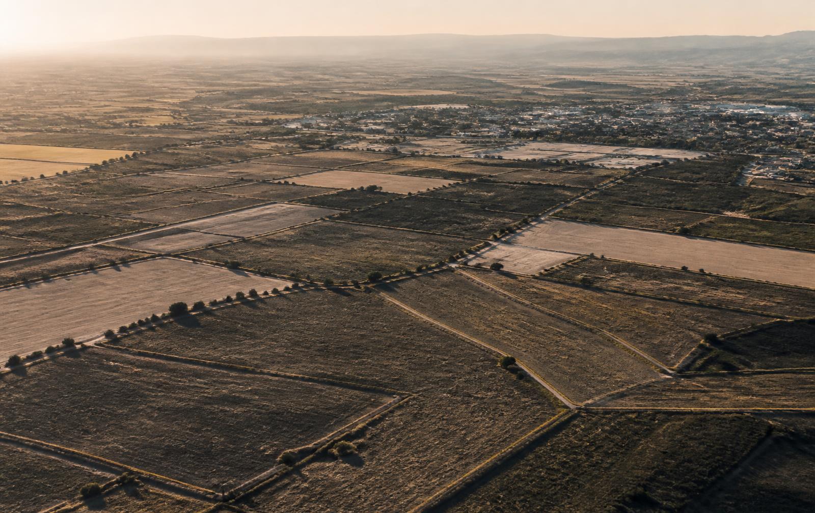 Vista aérea de parcelas de suelo urbanizable y rústico en la Comunidad de Madrid al atardecer